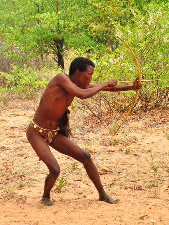 Ein Mann schießt mit einem kleinen Bogen - Namibia Urlaub mit Kindern