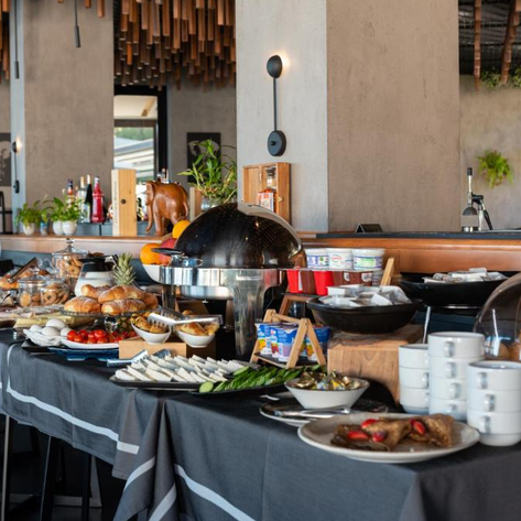 Ein reichhaltiges Frühstücksbuffet mit frischen Brötchen, Obst und verschiedenen Aufschnittsorten auf einem eleganten Tisch.