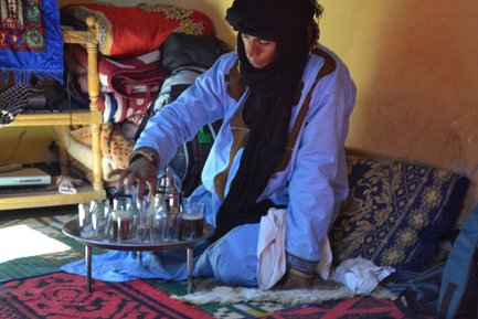 Gastfreundlicher Beduine reicht frisch aufgebrühten Tee in der Wüste – Marokko Familienreise