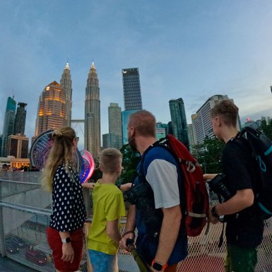 Familie posiert für ein Selfie vor der beleuchteten Skyline von Kuala Lumpur – Malaysia & Borneo Familienreise