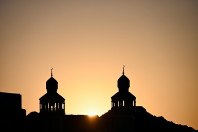 Sonnenuntergang über Muscat mit sichtbarem Minarett – Oman Reise mit Kindern