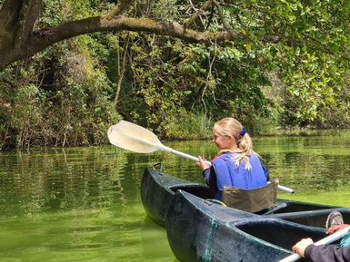 Mädchen genießt eine Kanutour auf dem ruhigen Duluti-See – Tansania mit Kindern