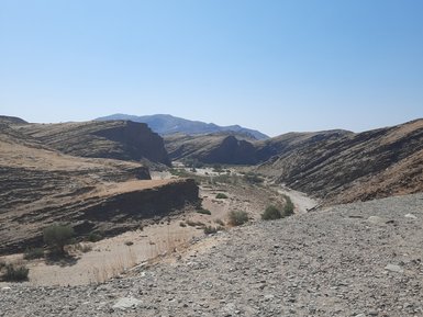 Eine staubige unasphaltierte Straße - Namibia mit Jugendlichen