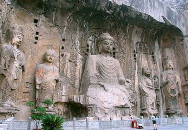 Imposante Buddha-Statuen sind in die Felsen gehauen, umgeben von kunstvollen Reliefs und einer ruhigen Atmosphäre.