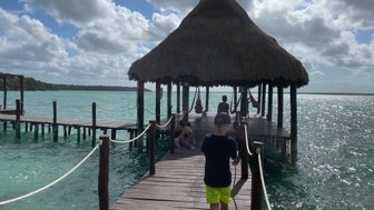 Holzbrücke mit Hütte über dem türkisfarbenen Wasser von Bacalar – Mexiko mit Kindern