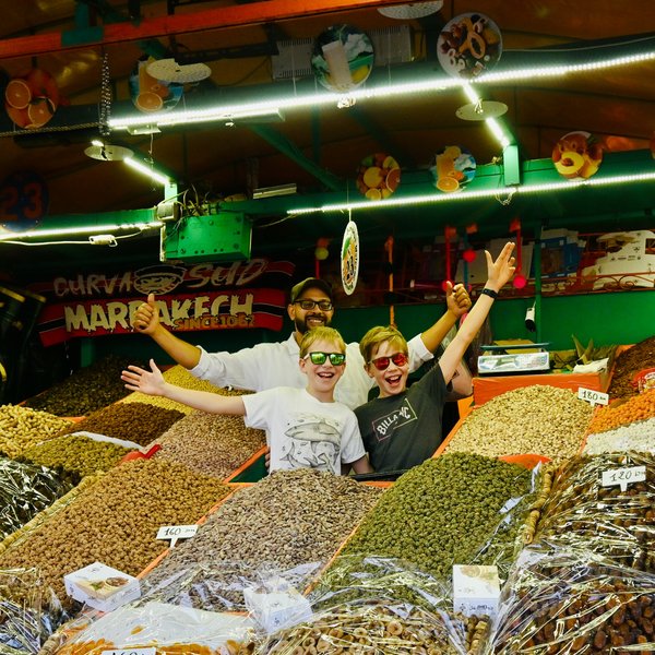 Zwei Kinder entdecken bunte Gewürze an einem traditionellen Marktstand in Marrakesch – Marokko Familienreise