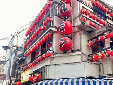 Ein traditionelles japanisches Restaurant mit roten Laternen und einem einladenden Eingang, umgeben von Fahrrädern.