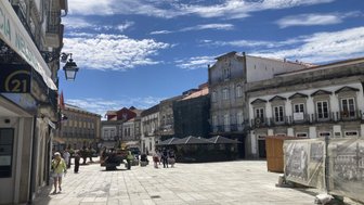 Eine belebte Straße in Viana do Castelo, umgeben von historischen Gebäuden und einem strahlend blauen Himmel.