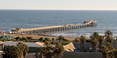 Der Fernblick auf das weite Meer mit einem Pier der ins Meer führt - Namibia Urlaub mit Kindern