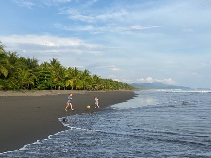 Kinder haben Spaß beim Ballspielen am Strand von Uvita – Costa Rica Familienreise