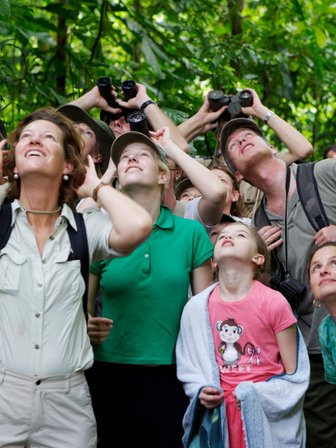 Familien beobachten aufmerksam die Tierwelt mit Ferngläsern im Regenwald – Costa Rica Familienreise