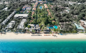 Ein weitläufiger Blick auf das Hotel Bandara Resort in Koh Samui, umgeben von üppigem Grün und dem klaren blauen Wasser.