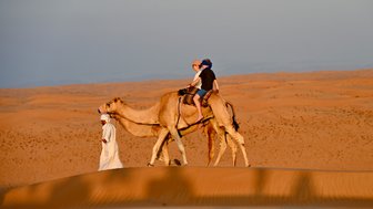 Kinder erleben ein Kamelreiten durch die goldenen Dünen der Wahiba Sands – Oman mit Kindern