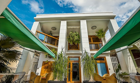 Ein einladender Außenbereich, großen Fenstern und einer Eingangstür, die ins Gebäude führt.