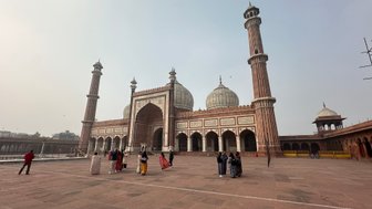 Die Jama Masjid in Delhi, umgeben von Besuchern, zeigt beeindruckende Architektur mit hohen Minaretten und Kuppeln.