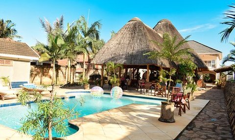 Ein einladender Poolbereich mit Palmen und einem Strohdach, ideal für Entspannung und Erholung unter der Sonne.