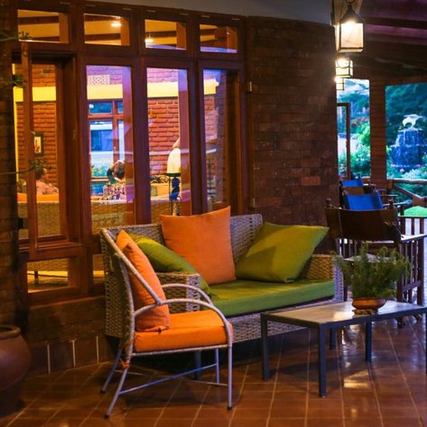 Ein gemütlicher Sitzbereich mit bunten Kissen und einem kleinen Tisch, umgeben von warmem Licht und einer einladenden Atmosphäre.