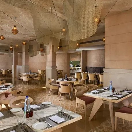Ein elegantes Restaurant mit modernen Holzmöbeln und sanfter Beleuchtung, das eine einladende Atmosphäre schafft.