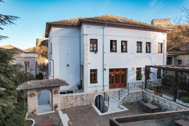 Das elegante Hotel Bineri in Gjirokaster zeigt eine moderne Fassade mit Holzfenstern und einem einladenden Eingangsbereich.