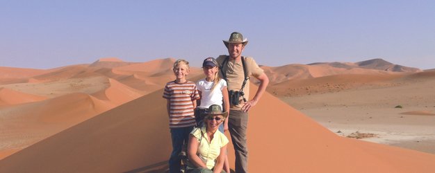 Eine Familie steht auf einer Sanddüne - Namibia mit Kindern