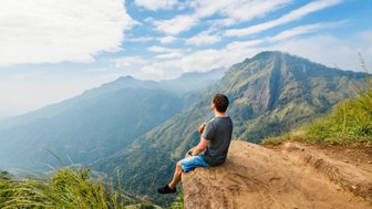 Junge macht eine Pause auf einem Felsen am Little Adam’s Peak Wanderweg in Ella – Sri Lanka Reise mit Kindern