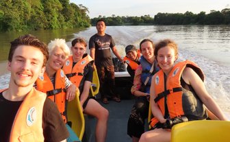 Familie posiert gemeinsam für ein Foto auf dem Boot während der Flusssafari am Kinabatangan – Malaysia & Borneo Familienreise