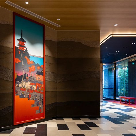 Ein stilvolles Lobby-Design mit einem großen, bunten Wandgemälde, das eine traditionelle japanische Szene darstellt.