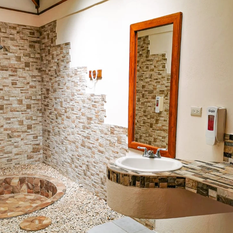 Ein modernes Badezimmer mit einer runden Badewanne, gefliestem Boden und einer eleganten Waschbeckenanordnung.