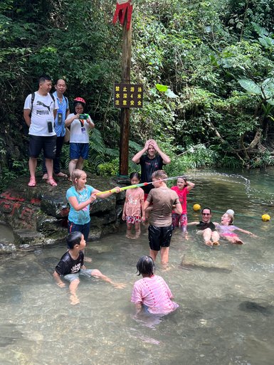 Fröhliche Kinder plantschen und spielen im klaren Wasser des Li-Flusses bei Yangshuo – China mit Kindern