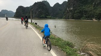 Personen radeln entlang der malerischen Küste der Halong-Bucht – Vietnam mit Kindern