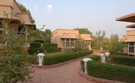 Eine malerische Resort-Anlage mit eleganten Bungalows, umgeben von üppigem Grün und gepflegten Gärten.