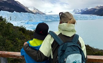 Eine Frau und ein Kind stehen am Geländer und betrachten den beeindruckenden Perito-Moreno-Gletscher in Patagonien.