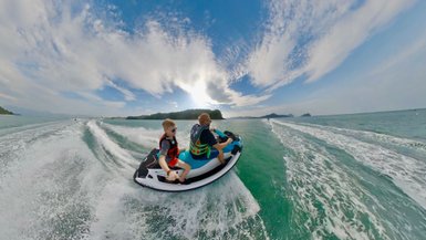Vater und Kind genießen gemeinsam eine Jetski-Fahrt auf dem Wasser vor der Küste von Langkawi – Malaysia & Borneo Reise mit Kindern