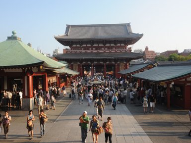 Eine belebte Straße vor dem Senso-ji Tempel in Asakusa, Tokio, mit vielen Besuchern und traditioneller Architektur.