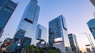 Hochmoderne Wolkenkratzer erheben sich majestätisch gegen den Abendhimmel in Gangnam, Seoul, umgeben von urbanem Leben.