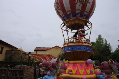 Ein bunter Heißluftballon mit Minnie Maus und Mickey Maus, umgeben von fröhlichen Zuschauern im Magic Kingdom.