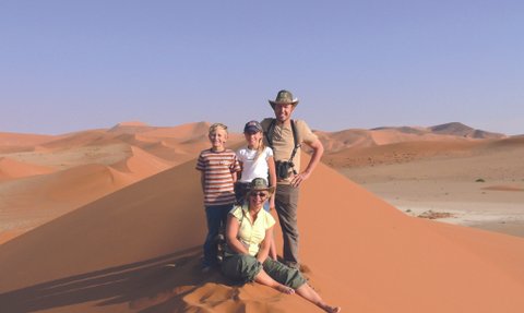 Eine Familie steht auf einer Sanddüne - Namibia mit Kindern