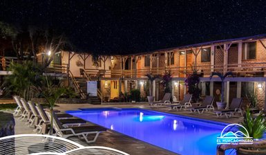 Ein einladender Hotelpool unter einem klaren Sternenhimmel, umgeben von gemütlichen Liegen und blühenden Pflanzen.