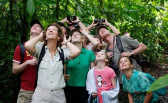 Familien beobachten aufmerksam die Tierwelt mit Ferngläsern im Regenwald – Costa Rica Familienreise