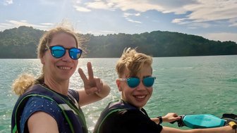 Mutter fährt mit ihrem Kind auf einem Jetski über das Meer vor Langkawi – Malaysia & Borneo Familienreise