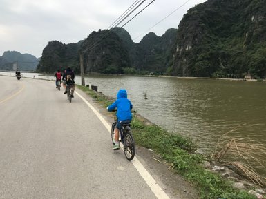 Personen radeln entlang der malerischen Küste der Halong-Bucht – Vietnam mit Kindern
