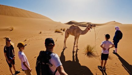 Familie hält ein Selfie mit einem Kamel in der Wüste fest – Marokko Reise mit Kindern
