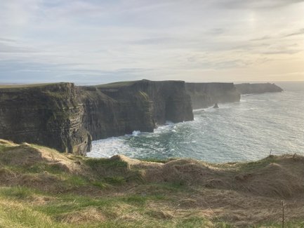 Die Klippen von Moher erheben sich majestätisch über dem tosenden Atlantik, umgeben von sanften grünen Hügeln.