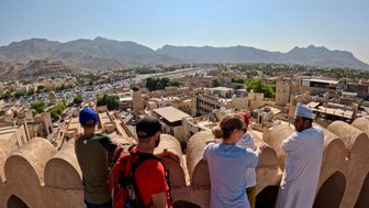 Familie und Einheimische genießen die Aussicht vom historischen Nizwa Fort – Oman Familienreise