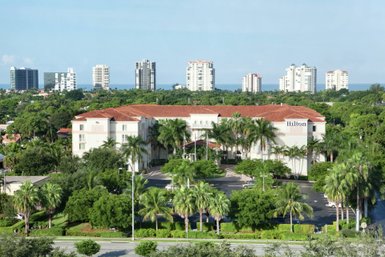 Ein luxuriöses Hilton-Hotel umgeben von üppigen tropischen Pflanzen und majestätischen Palmen, ideal für Entspannung.
