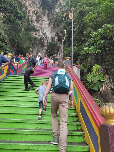 Besucher steigen die bunte Treppe zu den Batu-Höhlen hinauf – Malaysia & Borneo mit Kindern