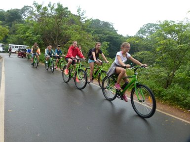 Kinder radeln durch eine grüne Umgebung auf einer Fahrradtour – Sri Lanka Familienreise