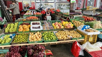 Ein lebhafter Bauernmarkt mit bunten Obst- und Gemüsekörben, die eine Vielzahl frischer Produkte präsentieren.