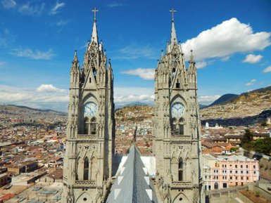 Die beeindruckenden Türme einer Kathedrale ragen hoch in den blauen Himmel, umgeben von einer malerischen Stadtlandschaft.