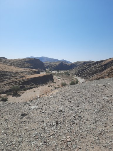 Eine staubige unasphaltierte Straße - Namibia mit Jugendlichen